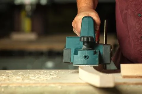 Carpenter working with electric planer. Stock Photos