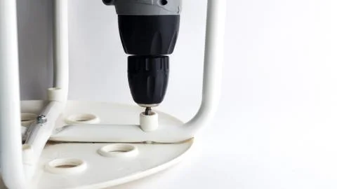 Carpenter working with an electric screwdriver on the work bench . Stock Photos