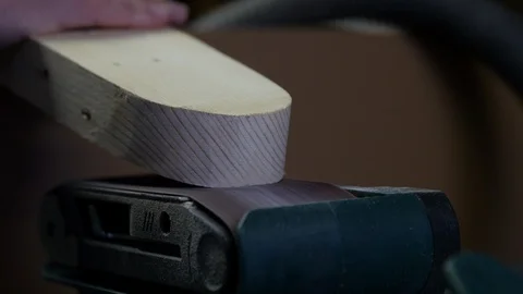 Carpenter working with electrical belt sander on wooden plank. This sanding work Stock Footage 127214957