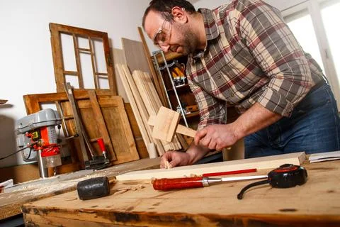 Carpenter working with a hammer, chisel and wood carving tools. Foto stock