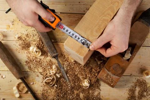 Carpenter working, hammer, meter and screw-driver on construction background. Stock Photos