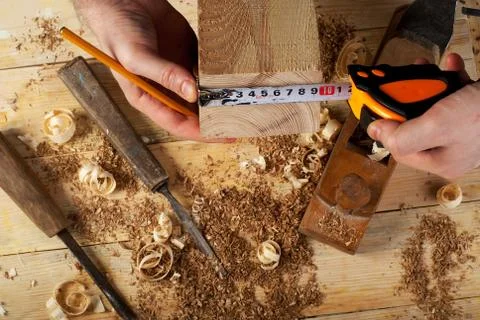 Carpenter working, hammer, meter and screw-driver on construction background. Stock Photos