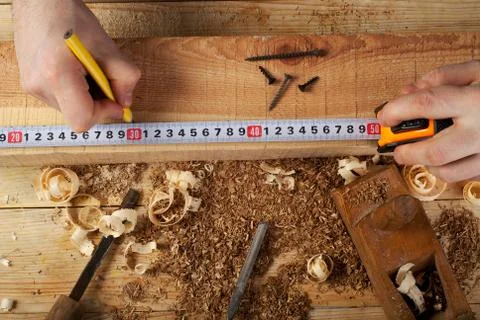 Carpenter working, hammer, meter and screw-driver on construction background. Stock Photos