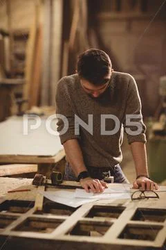 Carpenter Working On His Craft In A Dusty Workshop