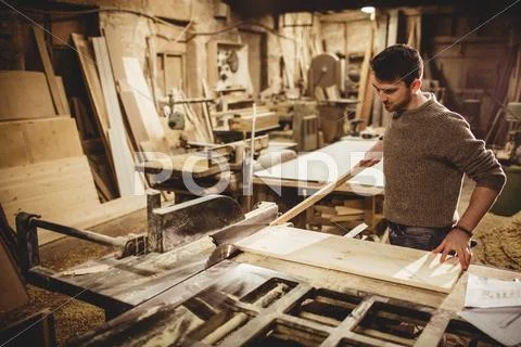 Carpenter Working On His Craft In A Dusty Workshop