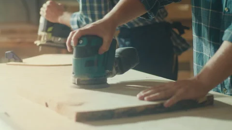 Carpenter Working With a Lathe, Another Carpenter Working Sanding Machine Stock Footage 224170104