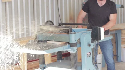Carpenter working on a machine cutting a wooden board in a carpentry workshop Video stock 173932832