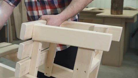 Carpenter working in a shirt with a beard in the workshop makes a wooden chair Stock-Footage 88886162