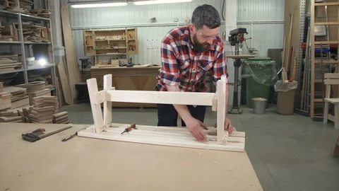 Carpenter working in a shirt with a beard in the workshop at work Stock Footage 88996700