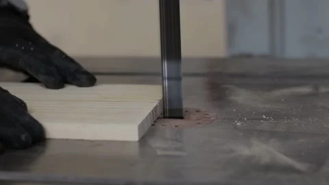 Carpenter working on a teble saw machine and cutting a wooden plank close up Video stock 173937597