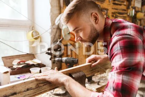 Carpenter working with wood plank at workshop Stock Photos