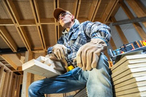 Carpenter working on wood projects in a workshop setting during day Stock Photos
