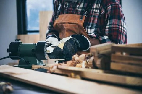 Carpenter working on woodworking machines in carpentry shop. woman works in a Stock Photos