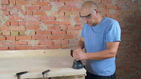 Carpenter working. Worker polishes board with a sander at his workshop. Stock Footage 162923585