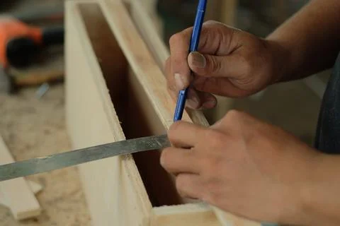 Carpenter working in workshop. carpenter measuring using pencil and ruler. Stock Photos