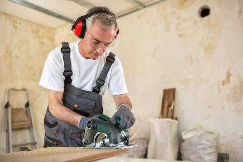 Carpenter is working in a workshop Stock Photos