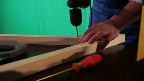 Carpenter works on the background of green screen Stock Footage 77638055