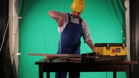 Carpenter works on the background of green screen Stock Footage 77638066