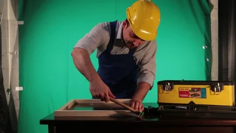 Carpenter works on the background of green screen Stock Footage 77638088