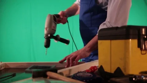 Carpenter works on the background of green screen Stock Footage 77840461