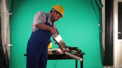 Carpenter works on the background of green screen Stock Footage 77840467