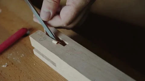 A carpenter works with a chisel to remove a layer of wood Stock Footage 156500582