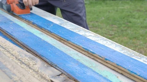 The carpenter works as an electric bank. Processing an old wooden board Stock Footage 130111793