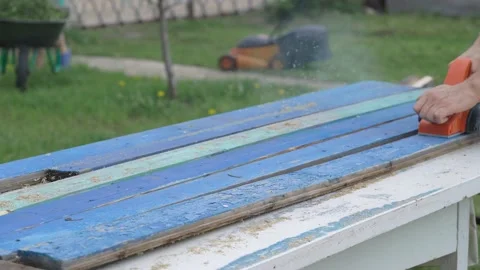 The carpenter works as an electric bank. Processing an old wooden board Stock-Footage 130749768