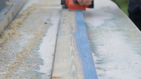 The carpenter works as an electric bank. Processing an old wooden board Video stock 130780807