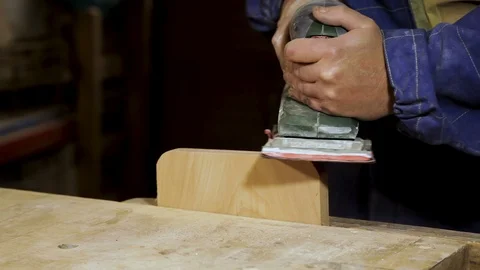 Carpenter works with a grinding machine on the workbench in the workshop. Stock Footage 100877140