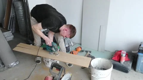 Carpenter works on wood project in a simple indoor space with tools and material Stock Footage 337525468