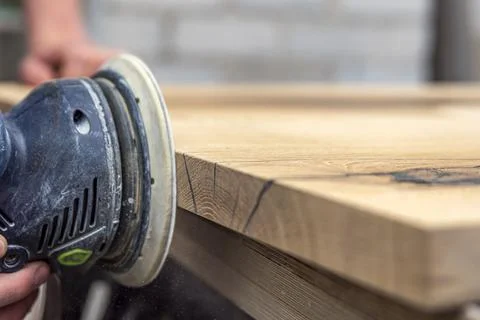 A carpenter works in a workshop. Joiner's grinders, furniture manufacturing. A Stock Photos