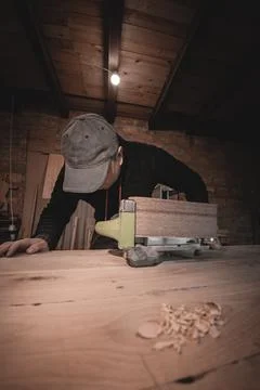 A carpenter works in a workshop. Joiner's grinders, furniture manufacturing.  Stock Photos