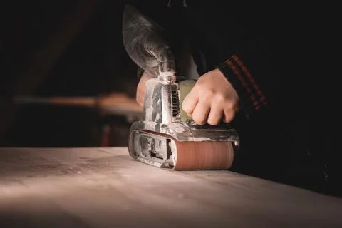 A carpenter works in a workshop. Joiner's grinders, furniture manufacturing.  Stock Photos