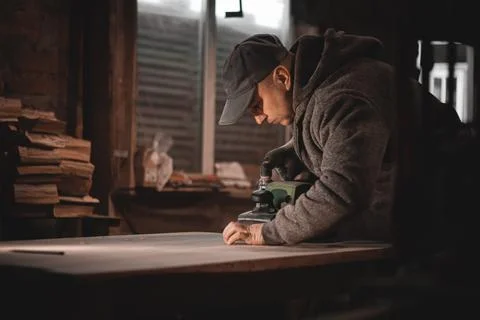 A carpenter works in a workshop. Joiner's grinders, furniture manufacturing.  Stock Photos