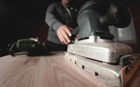 A carpenter works in a workshop. Joiner's grinders, furniture manufacturing.  Stock Photos