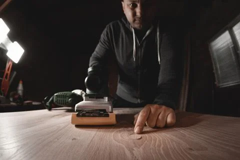 A carpenter works in a workshop. Joiner's grinders, furniture manufacturing.  Stock Photos