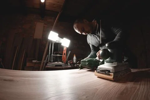 A carpenter works in a workshop. Joiner's grinders, furniture manufacturing.  Stock Photos