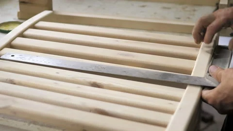 The carpenter in this workshop assembles a handmade chair, measures the details Stock Footage 202130013