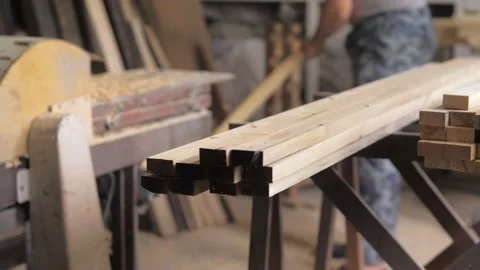 A carpenter in the workshop works on a woodworking machine, processes and aligns Stock Footage 201048987