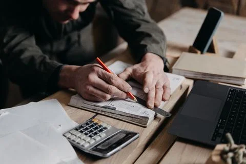 Carpenter writes on a notebook 스톡 사진