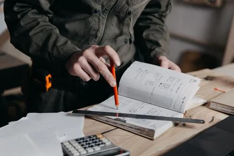 Carpenter writes on a notebook Stock Photos