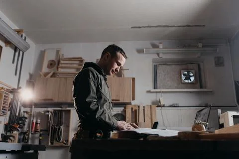 Carpenter writes on a notebook 스톡 사진