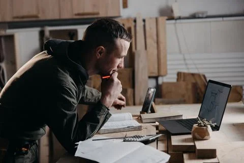 Carpenter writes on a notebook Stock Photos