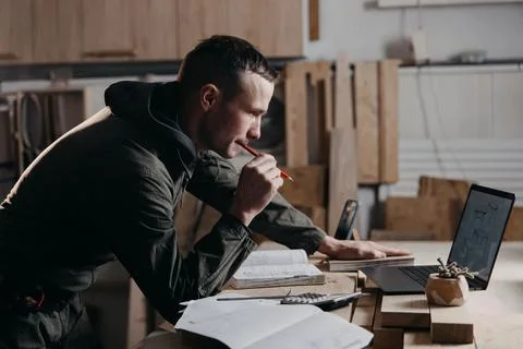 Carpenter writes on a notebook Stock Photos