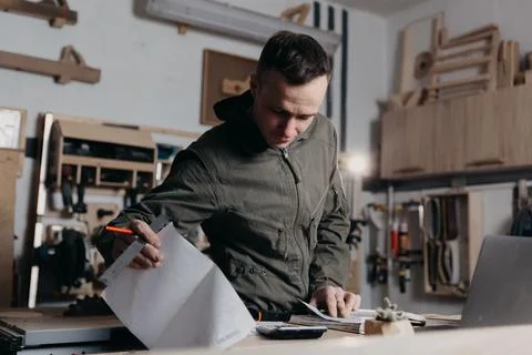 Carpenter writes on a notebook Stock Photos