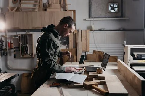 Carpenter writes on a notebook Stock Photos
