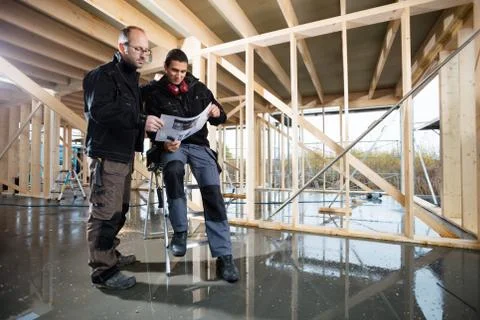 Carpenters Analyzing Plan At Construction Site Stock Photos