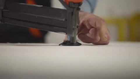 Carpenter's hand who are assembling the  cabinet by using a nail gun Stock Footage 168636048