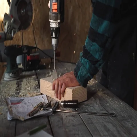 Carpenter's hands using drill on wooden plank Stock Footage 69538373